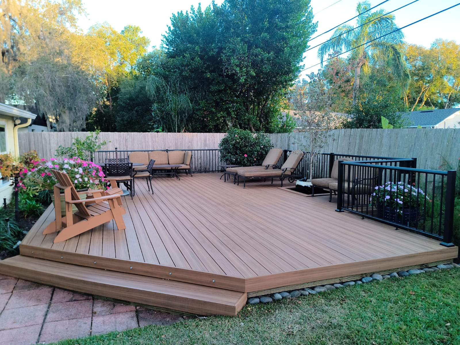 Wide composite deck with Adirondack chairs and step lighting