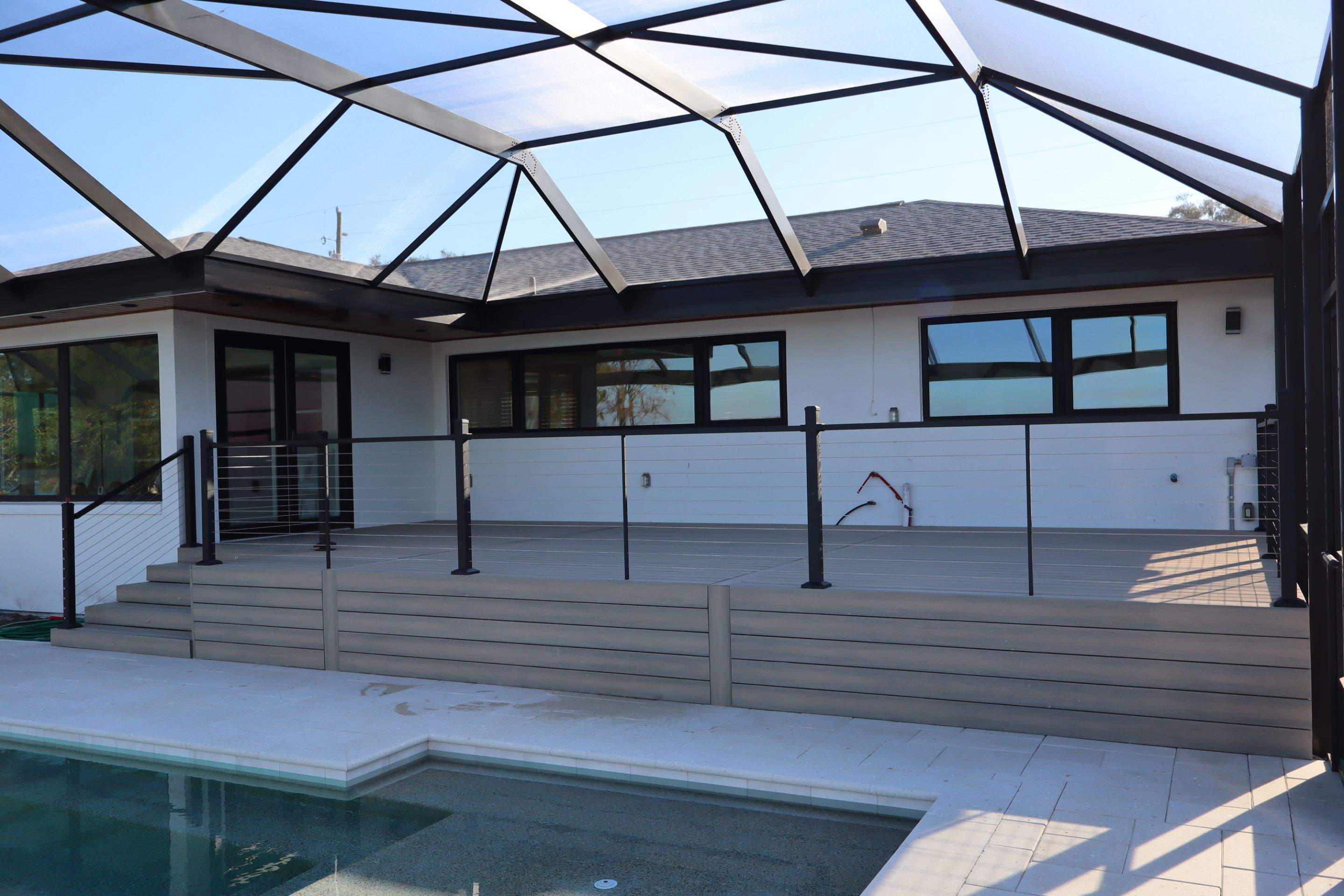 Wide elevated deck with cable railing and pool steps